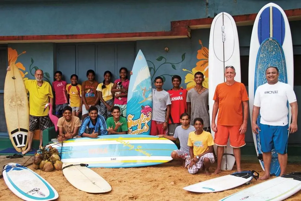 Surfer standing above the ocean holding a surfboard