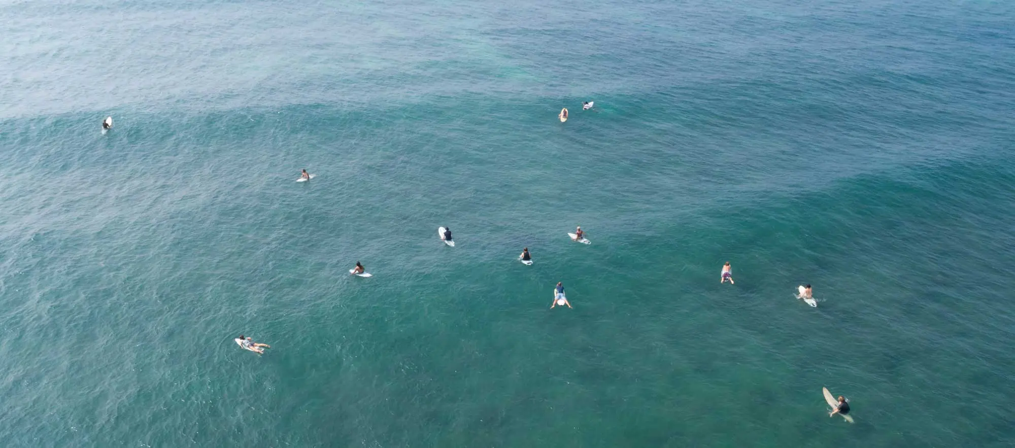 Surfers paddling and surfing in the ocean in Goa